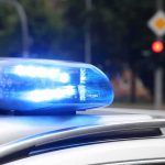 Troops KILLED in Car By Drunk Driver Police officers standing and sitting near a patrol car.