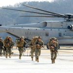 2 U.S Servicemen KILLED – Iran Clash Escalates Soldiers disembark and walk past a large military helicopter