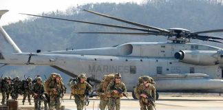 2 U.S Servicemen KILLED – Iran Clash Escalates Soldiers disembark and walk past a large military helicopter