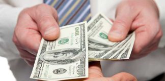 Trump Unveils The NEW $100 Bill! Two hands exchanging cash bills in a business context