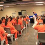 Last-Minute Gender Change BACKFIRES – Convict Denied Transfer! Group of inmates in orange uniforms attending a class in a prison hall