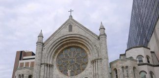 Arson Strikes Historic 140-Year-Old Church—Twice Stone church facade with large rose window and cross