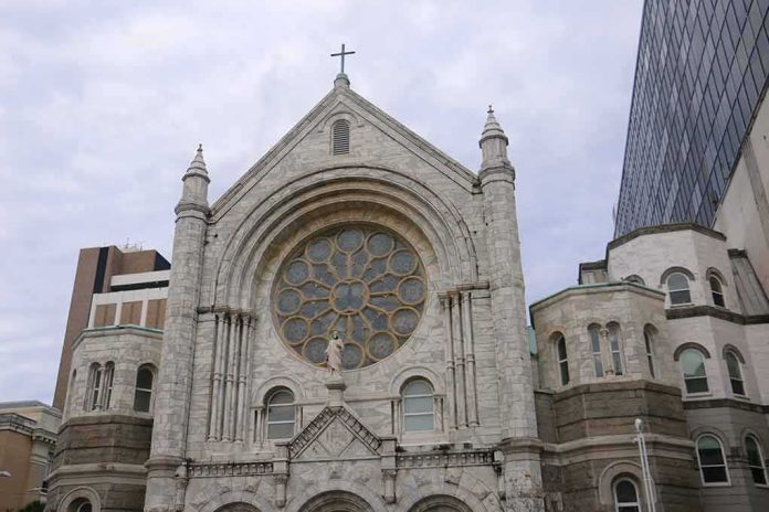 Stone church facade with large rose window and cross