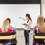 School Teacher’s DISGUSTING Fourth of July Post Lands Her in Hot Water A teacher presenting to students in a classroom