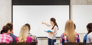 School Teacher’s DISGUSTING Fourth of July Post Lands Her in Hot Water A teacher presenting to students in a classroom