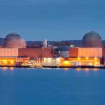 Nuclear Plant LEAKED – Chernobyl 2.0? nuclear power plant with two domed reactor buildings by water at dusk