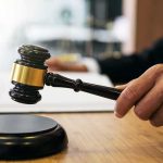 Court Greenlights AI Child Sex Pics At Home Judge's hand holding a gavel over a sound block