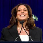 smiling woman speaking at a podium