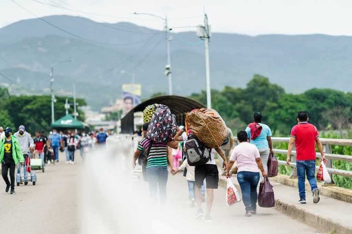 shutterstock_2167628739 People walking across a bridge carrying bags and bundles