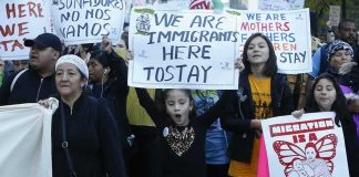 Government Warns Of ‘Civil War’ Plot Against Migrants Protesters march holding signs and banners
