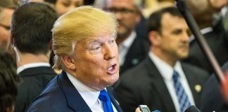 Trump Torches Fox News Reporter, Fires Warning Shot man in suit speaking to reporters with microphones
