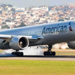 airliner landing on runway with smoke from tires