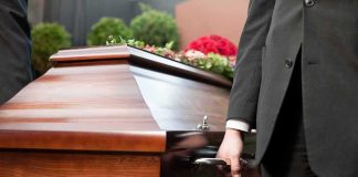 Pallbearer holding a wooden casket handle