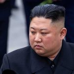 Kim Jong-Un looking to the side in a dark overcoat