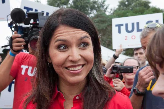 Tulsi Gabbard smiling at an outdoor event surrounded by supporters