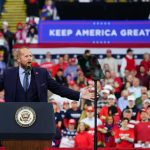 Trump Torches LeBron — Calls Him Racist Crowd at a political rally with a speaker at a podium; Stephen Paea, Curtis Lofton, Walter Jones, John Sullivan, and Colin David Jones present