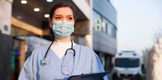 Actress Dead, DEA Crashes In – What They Found… Healthcare worker in scrubs wearing mask and gloves holding a clipboard