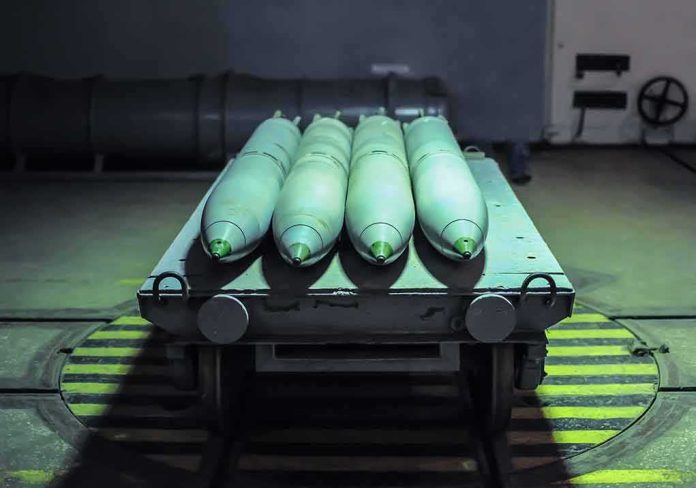 Green missiles on a wheeled cart in an industrial bay
