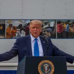 Trump’s Coast Guard Speech Sparks OUTRAGE! Donald Trump speaks at a podium with arms outstretched