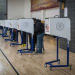 Trump Flexes as MAGA-Endorsed Primary Candidates Surge to Victory Voters at polling booths in a gymnasium