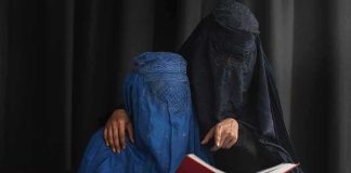 Burka School Crackdown Ignites Fury! Two veiled women reading a red book together