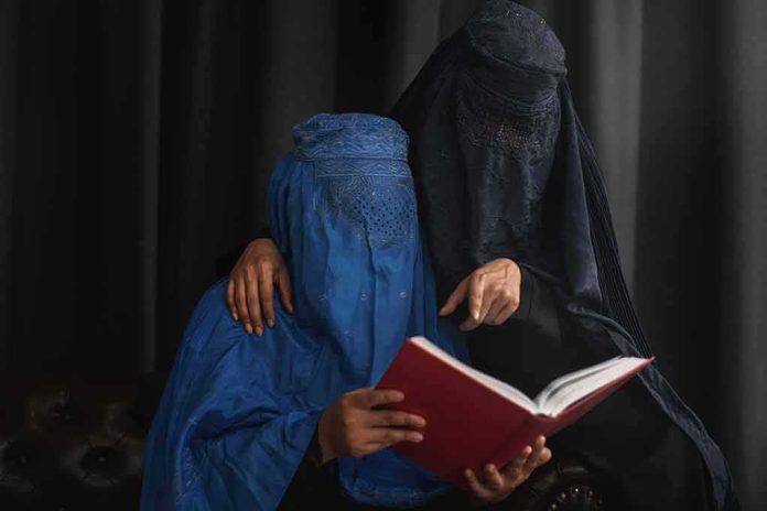 Two veiled women reading a red book together