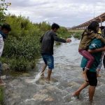 5 DROWNED In Summer Camp Horror Group of people wading across a shallow creek carrying children