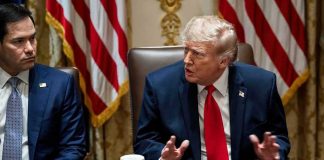 Donald Trump speaks at a meeting beside Marco Rubio at a conference table
