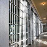Prison cell block with metal bars and corridor