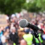 microphone on stand in front of a blurred crowd