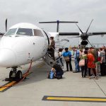Runway CHAOS — Migrants Refuse to Get Off Plane Passengers boarding a white turboprop airplane on the tarmac