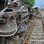 Overturned train cars beside railway tracks
