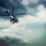 Police helicopter flying under dark storm clouds