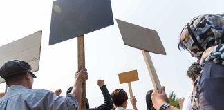 Group of people holding protest signs outdoors