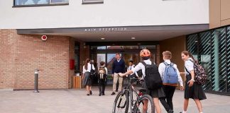 Students in uniforms arriving at a school entrance
