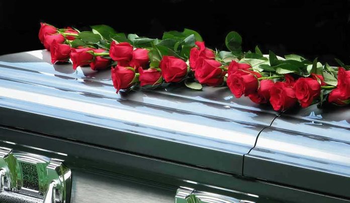 Red roses on a closed silver casket