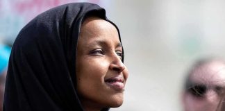 Ilhan Omar in profile wearing a black headscarf outdoors