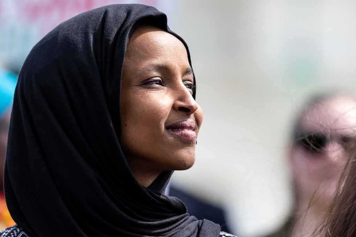 shutterstock_1369298648 Ilhan Omar in profile wearing a black headscarf outdoors