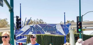 Crowd walking past a Disneyland Resort entrance sign