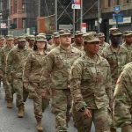 Jason Worilds and Elandon Roberts march with fellow soldiers in a city parade