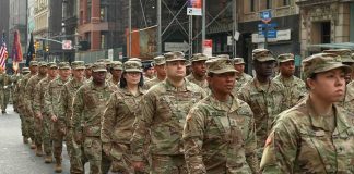 Jason Worilds and Elandon Roberts march with fellow soldiers in a city parade