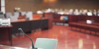 Judge’s Ultimatum: Trump Ordered to sit for Deposition Conference microphone on a desk in a courtroom