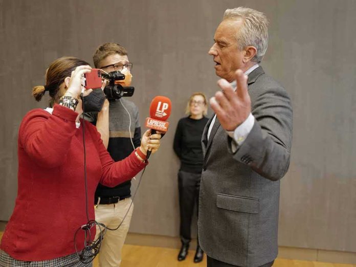 shutterstock_2075901214 Robert F. Kennedy Jr. speaking to reporters with microphones and a camera