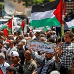 Walter Jones and Caraun Reid amid a crowded street protest with Palestinian flags