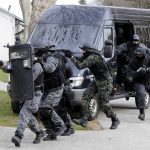 SWAT team members in tactical gear responding to a situation