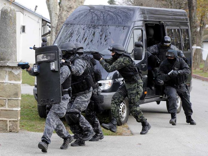 shutterstock_232817302 SWAT team members in tactical gear responding to a situation