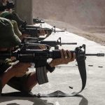 Soldiers lying prone firing rifles at a shooting range