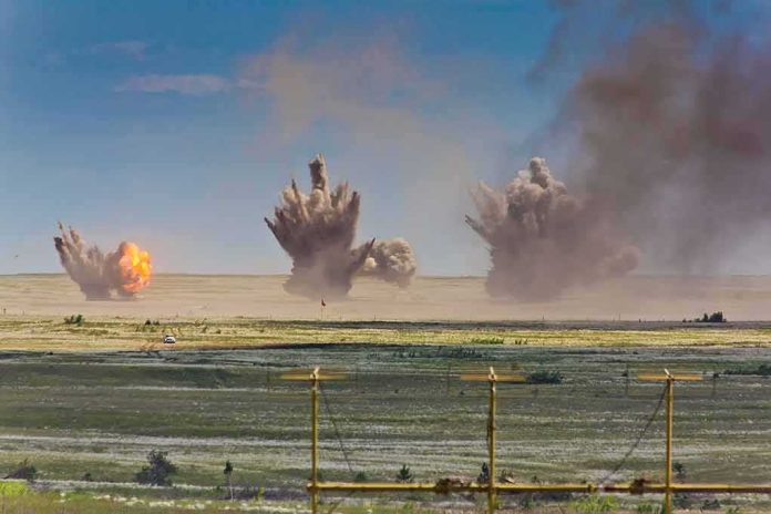 Multiple explosions erupt on a distant desert plain