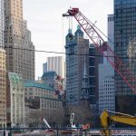 Construction cranes amid city skyscrapers